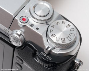The top of the camera features a solidly crafted mode dial with metal shutter button and front ring