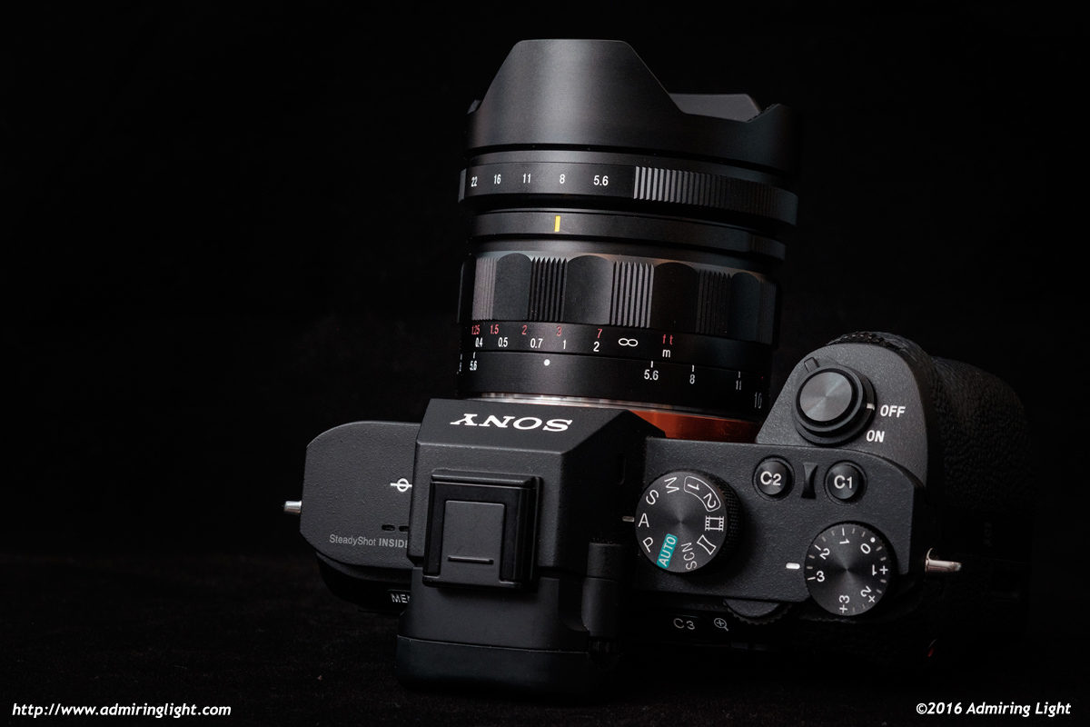 The lens has a built-in metal lens hood and nicely made aperture and focus rings.
